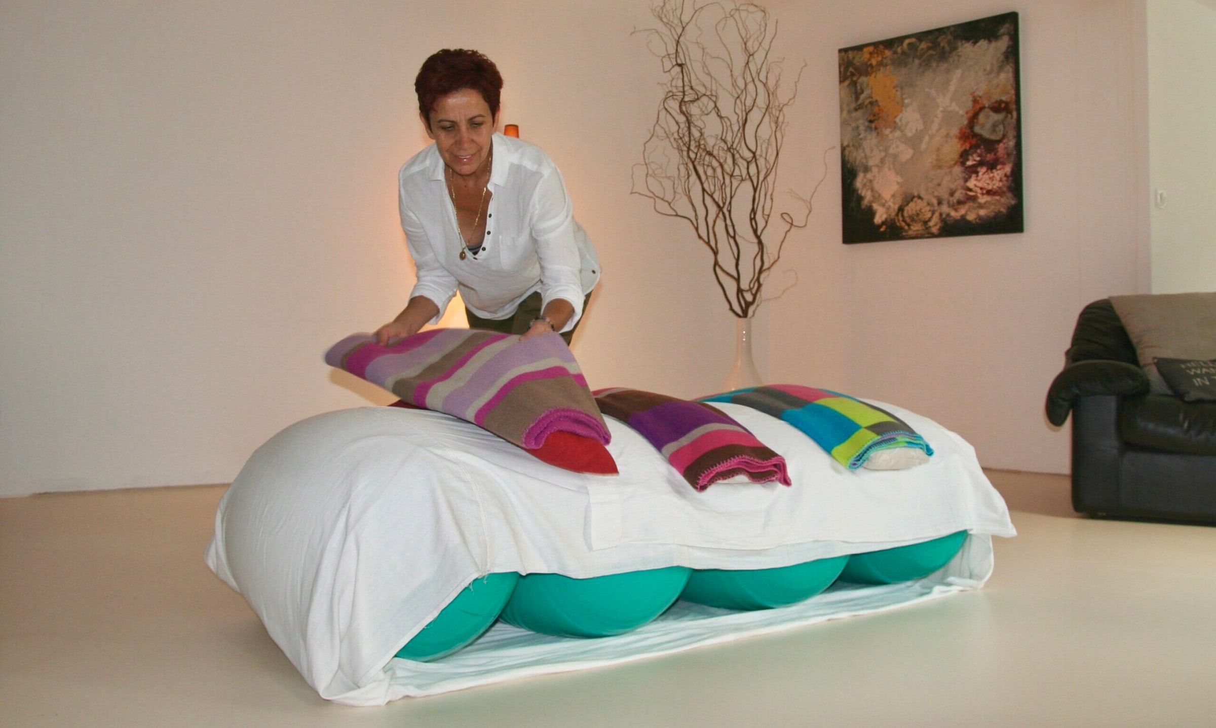 Isabella Porru prépare la table de ballons recouverte de coussins colorés